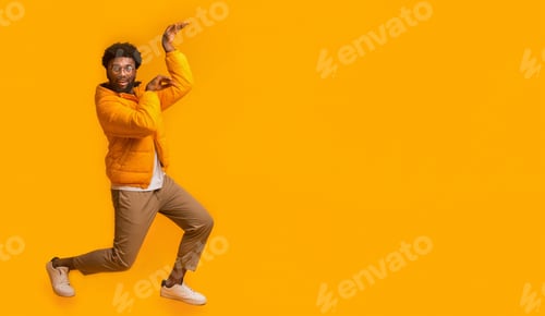 Preview: Winter black man dancing in egypt style on orange background