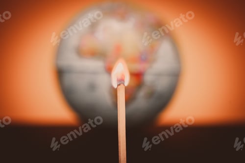 Preview: Burning match on blurred world globe background, concept of saving the earth from fires