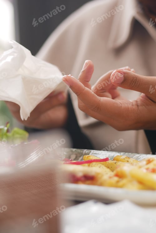 Preview: Hands cleaning fingers after enjoying a meal at a restaurant