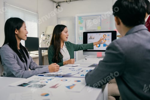 Preview: Asian businesswoman leading meeting and pointing at charts on computer screen