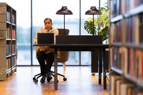 Preview: Student studying at library desk