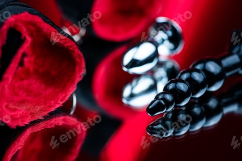 Preview: erotic bdsm toys for intimate sex games black silicone butt plug on the background of red handcuffs