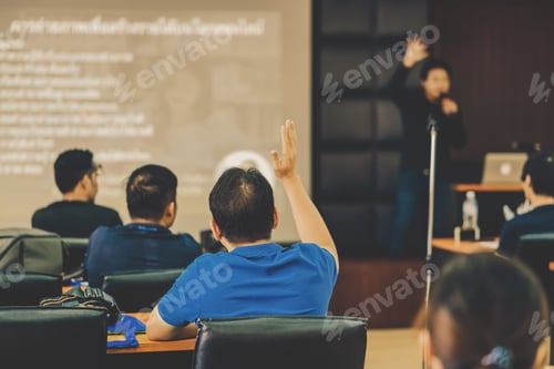 Preview: Rear view of Audience showing hand to answer the question from Speaker on the stage