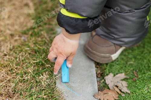 Preview: Child Drawing with Blue Chalk Outdoors Closeup