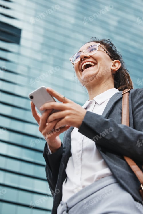 Preview: Phone, smile and business woman in city from below for location, search and walking on building bac