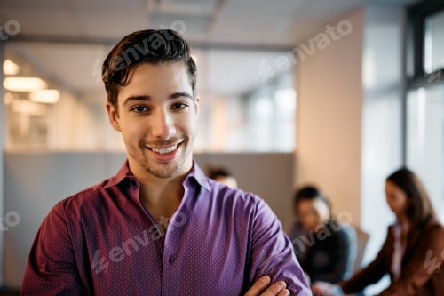 Preview: Young happy businessman in the office looking at camera.