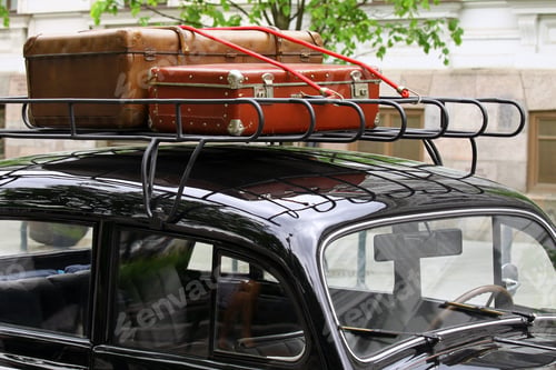 Preview: Vintage leather suitcases packed on top of the old car roof