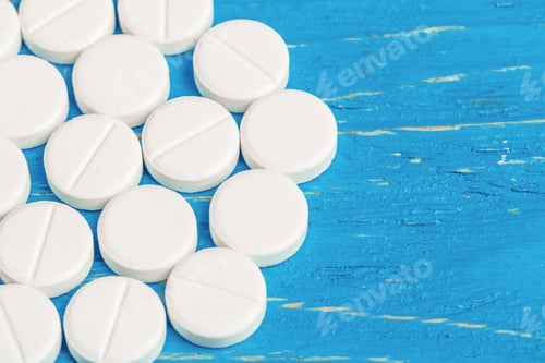 Preview: Bright blue wooden background with spillt white tablets