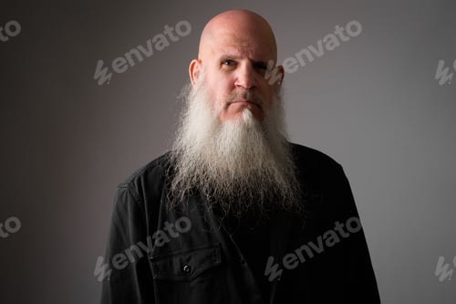 Preview: Face of mature bald man with long gray beard looking at camera
