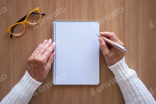 Preview: Close-up of woman hands with pen writing on notebook