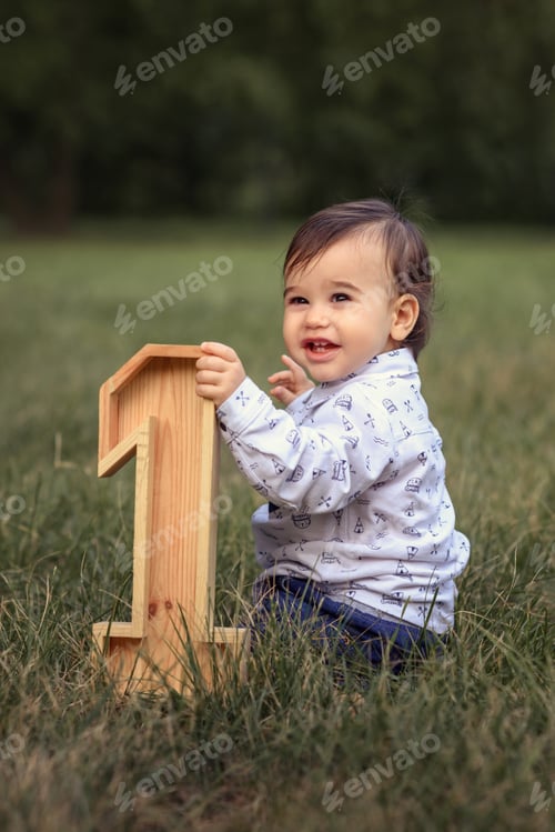 Preview: curly hair diverse boy outdoors having fun and playing around Happy birthday 1 year