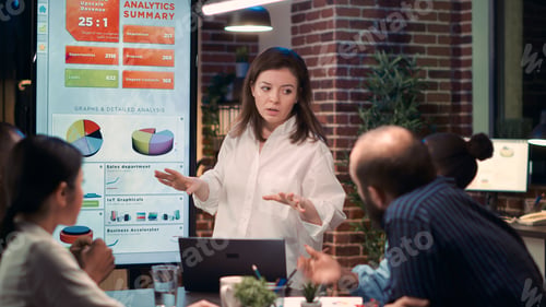 Preview: Businesswoman giving presentation in business meeting, holding laptop