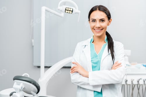 Preview: beautiful dentist standing with crossed arms in dental clinic