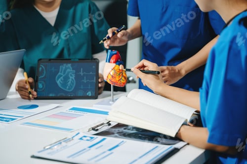 Preview: Group of medical students in uniform studying heart anatomy with tablet, notes, and lab reports