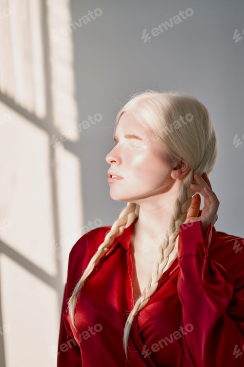 Preview: Pretty inclusive albino girl wearing red shirt on white background.