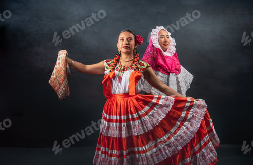 Preview: Two women in traditional Mexican clothing are dancing together