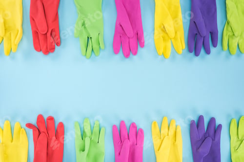 Preview: top view of multicolored bright rubber gloves on blue background with copy space