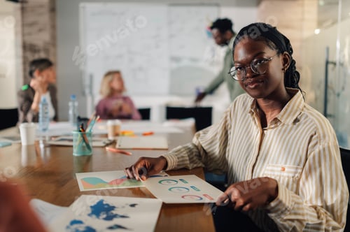 Preview: Young african american manager leading business meeting with charts and graphs