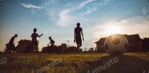 Preview: Kids playing soccer football under the sunset