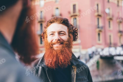 Preview: Young male hipster twins with red hair and beards talking on street