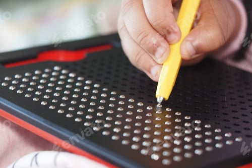 Preview: Child Engaging with Magnetic Dot Drawing Board for Creative Play