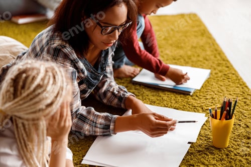 Preview: Children and teacher drawing together at school