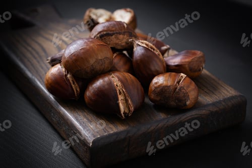 Preview: Roasted chestnuts on dark wooden background