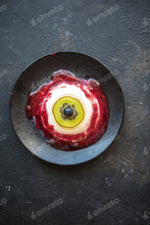 Preview: Halloween dessert bloody eye from vanilla panna cotta and kiwi with berry syrup