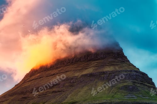 Preview: Kirkjufell mountain peak with colorful cloud covered in the sunset on summer at Iceland