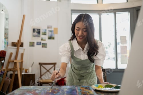 Preview: Asian woman is painting art. She is a professional artist. Watercolor artist is painting art on pape