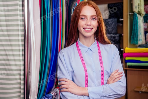 Preview: redhair ginger woman choosing color textile in tailor shop