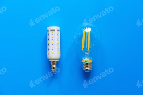 Preview: Light bulbs on blue paper background close up