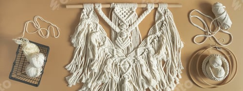 Preview: Macrame. Handmade macrame weaving and cotton threads on a rustic wooden stick.