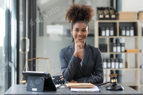 Preview: Confident young woman lawyer sitting in office and looking at camera.
