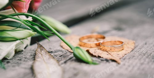 Preview: Gold wedding rings on orange, autumn leave