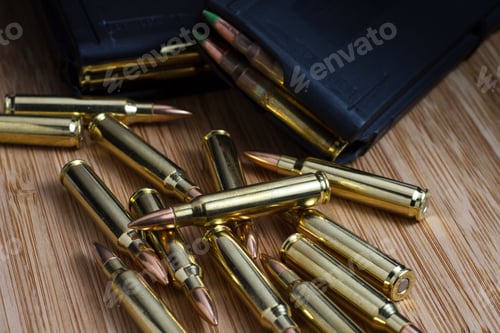 Preview: 5.56x45mm (.223) AR-15 bullets laid out next to two loaded magazines full of ammunition