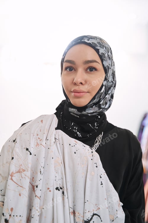 Preview: Happy young muslim woman enjoying work as tailor