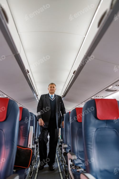 Preview: Male aircraft pilot walking down aircraft passenger salon