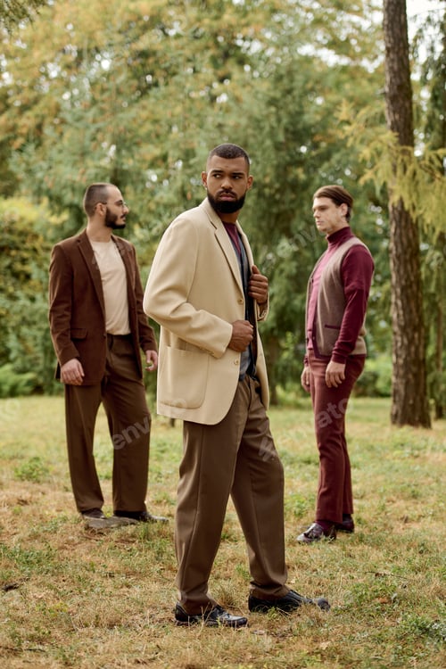 Preview: Three stylish men in autumn outfits pose among vibrant fall foliage