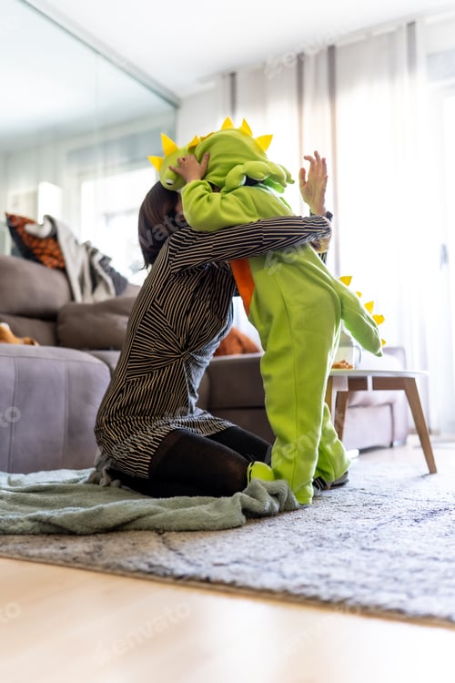 Preview: Mother hugging son wearing dinosaur costume at home