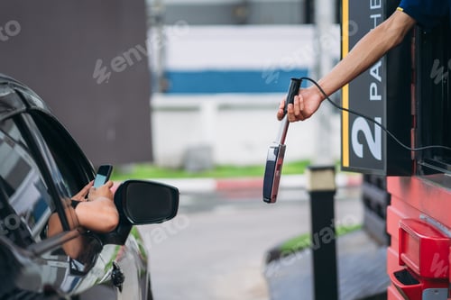 Preview: Young Man Pay for food or drinks via mobile phone at drive thru counter.