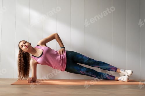 Preview: Woman in fashionable sportswear is doing exercise.