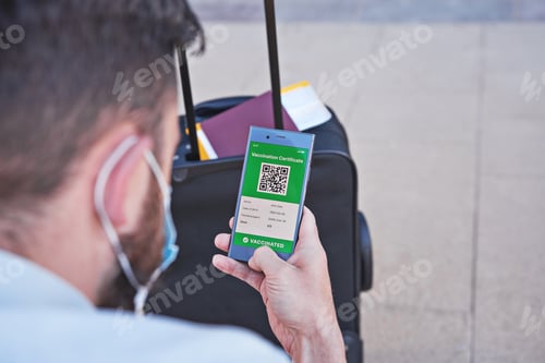 Preview: Vaccinated man using digital health passport app in mobile phone for travel during covid-19 pandemic