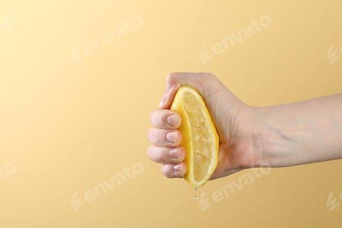 Preview: Woman squeezing lemon on yellow background, closeup. Space for text
