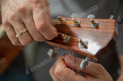 Preview: A man tunes an acoustic guitar,