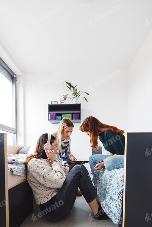 Preview: Vertical photo of three young women, friends spending time together in the dorm
