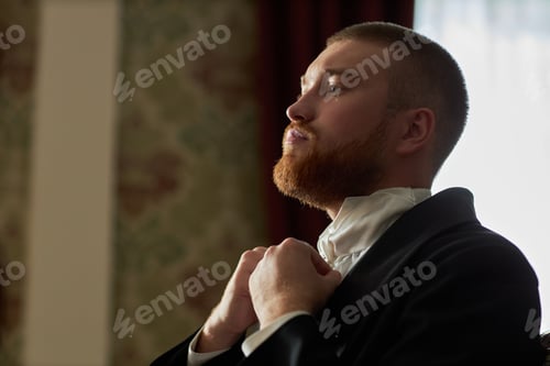 Preview: Gentleman Adjusting Tie Looking in Mirror