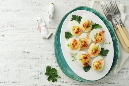 Preview: Easter stuffed eggs. Traditional Easter brunch or dinner with stuffed eggs with paprika, carrot cake