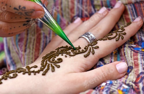 Preview: Human hand being decorated with henna tattoo