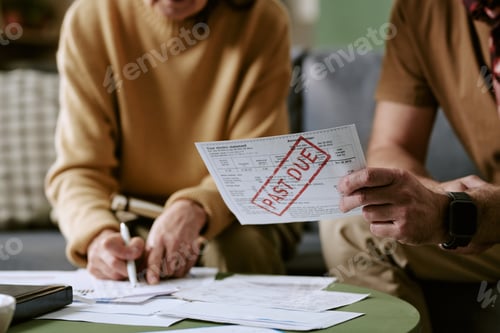 Preview: Couple Reviewing Past Due Bills and Writing Financial Notes